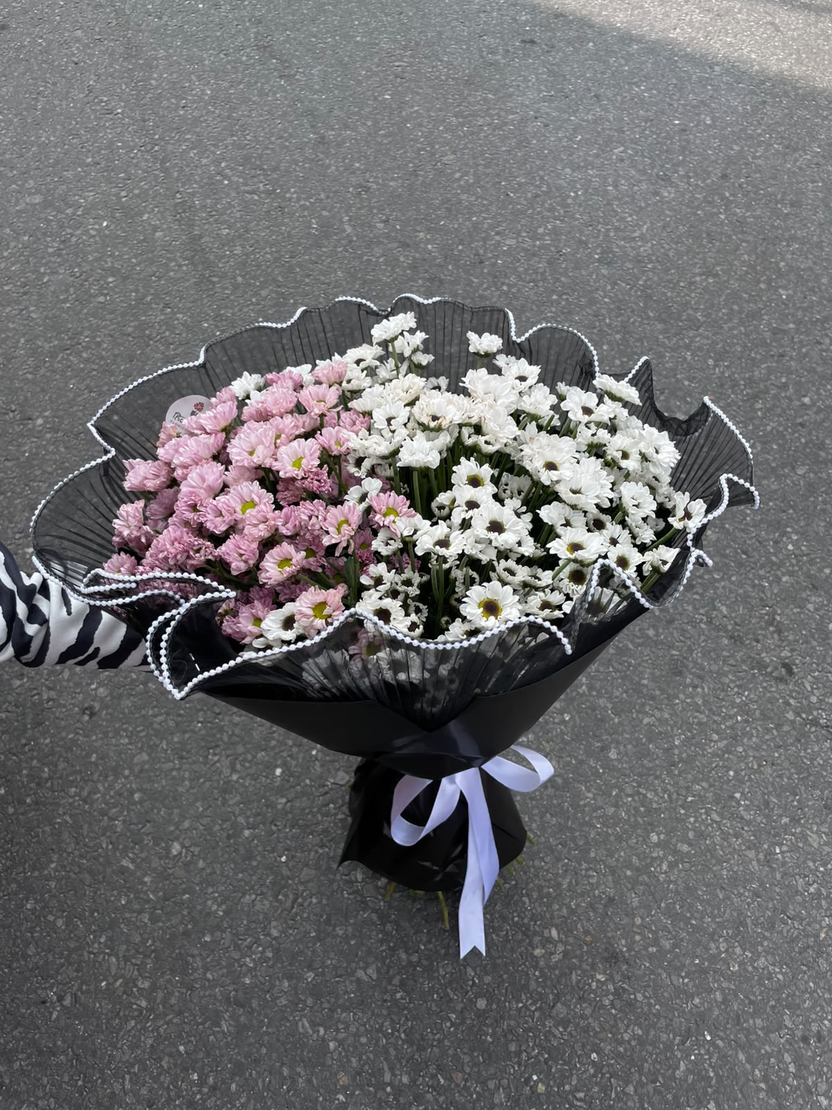Elegant Daisy Bouquet A graceful bouquet featuring 20 stems of purple and white-bottom daisies, wrapped in delicate net paper for a soft and elegant presentation.