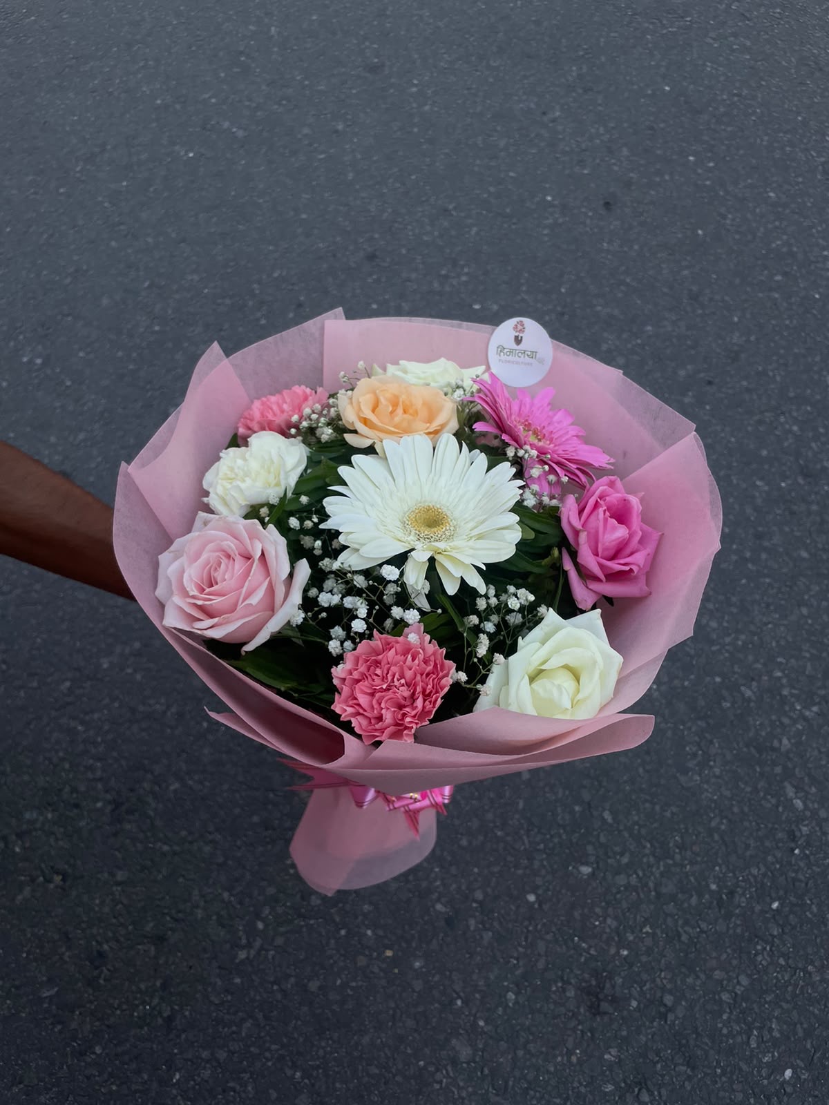 An elegant mix of pink, white, and peach blooms, beautifully wrapped in pastel pink for a romantic and sophisticated floral gift.