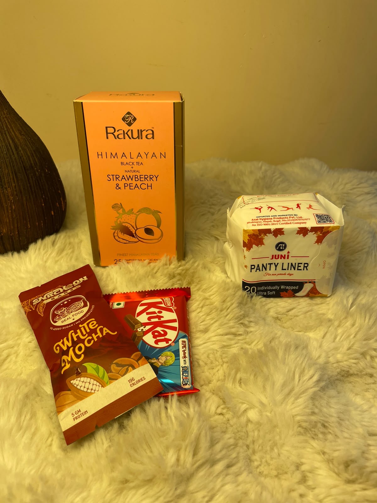 Sweet Period Care Set A compact care package featuring flavored black tea, a protein bar snack, KitKat, and a panty liner.