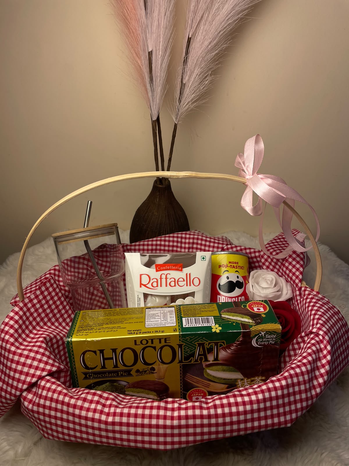 Sweet Festive Gift Set A delightful festive hamper combining a glass tumbler with Raffaello, mini Pringles, and a packet of chocolate.