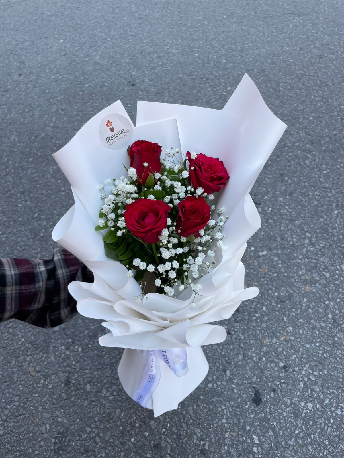 A charming bouquet featuring 4 fresh red roses, delicately complemented with Gypsophila (Gipsy) and beautifully wrapped in a clean white wrapper. Its simple and elegant presentation makes it a lovely choice for thoughtful gifting.