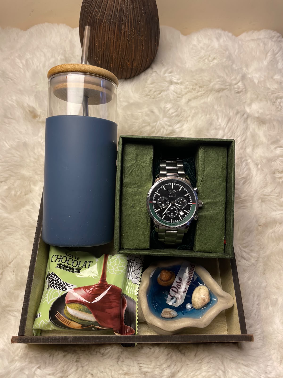 Luxury Lifestyle Gift Set A premium festive gift set featuring a water tumbler, chocolate pie, premium watch, and scented candle, thoughtfully arranged for a sophisticated presentation.