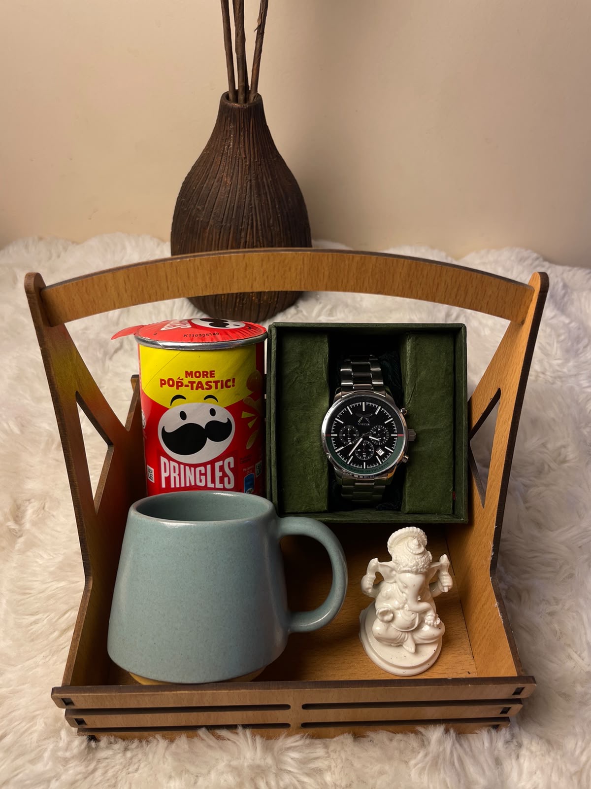 Classic Celebration Hamper A unique festive gift combining a mini Pringles, cup, watch, and Ganesh statue in one thoughtful presentation.