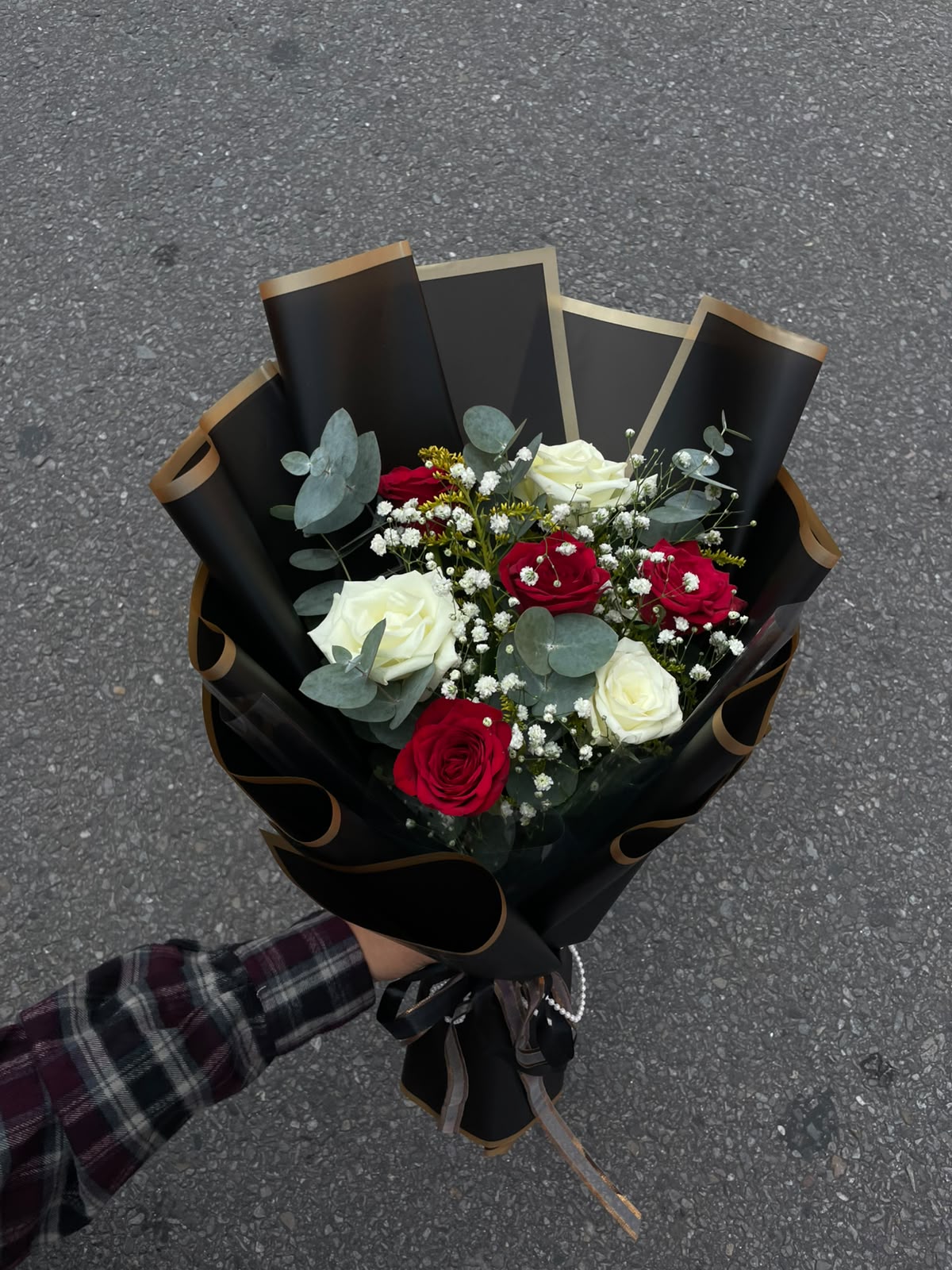 Classic Red & White Rose Bouquet A graceful combination of red and white roses, complemented by delicate Gypsophila (Gipsy) and Silver Dollar foliage. Finished with a premium black wrapper, this bouquet offers a striking and elegant presentation.