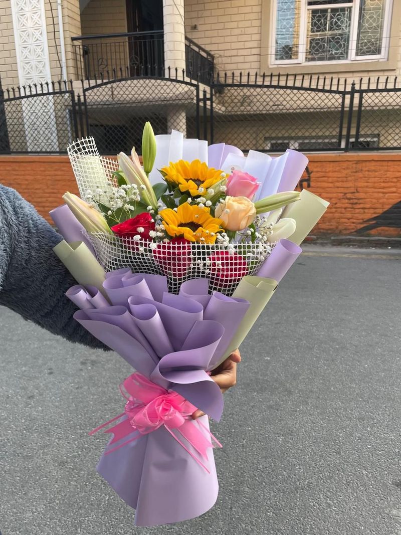 The Radiant Symphony – Premium Sunflower, Lily & Mixed Rose Net Bouquet