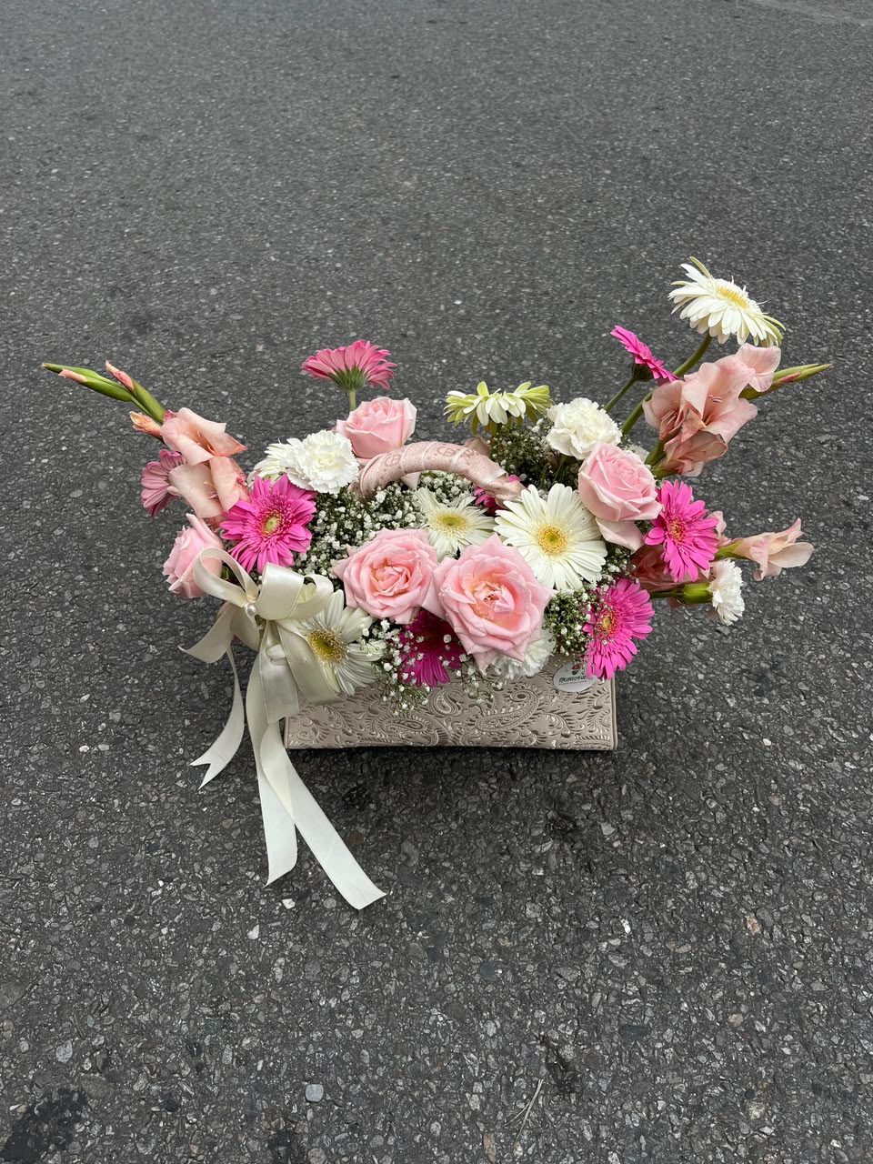 The bag design, flower varieties, colors, and arrangement style may vary slightly based on seasonal availability while maintaining the same quality and overall aesthetic.