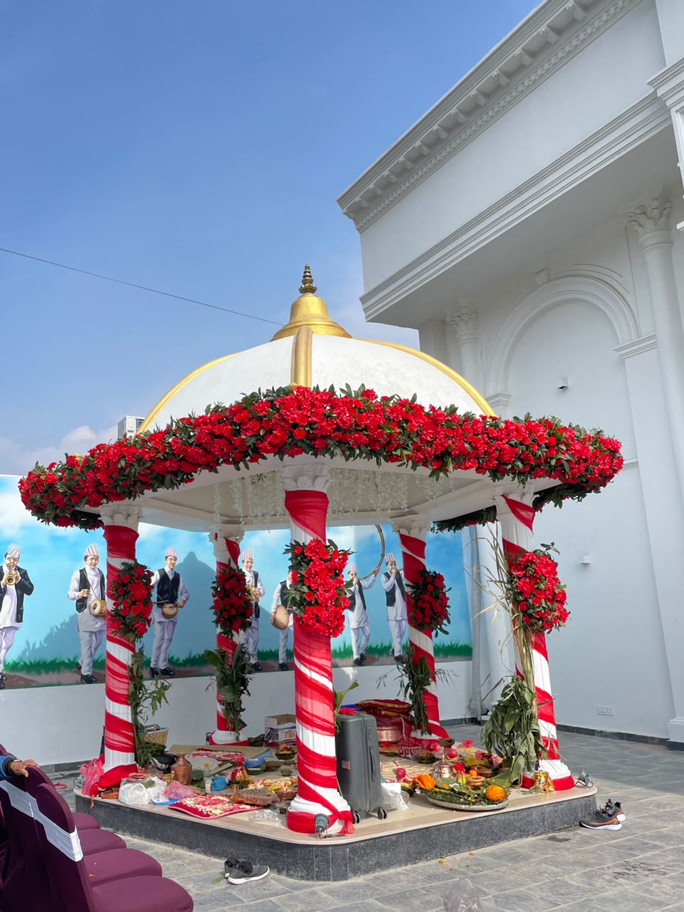 This setup offers a classic blend of sacred tradition and rich visual drama that brings warmth and energy to any wedding venue. The contrast of bold red blooms with clean white accents creates a striking focal point for the couple, while the elevated gazebo design ensures perfect visibility for guests and produces stunning framed photo memories throughout the ceremony.