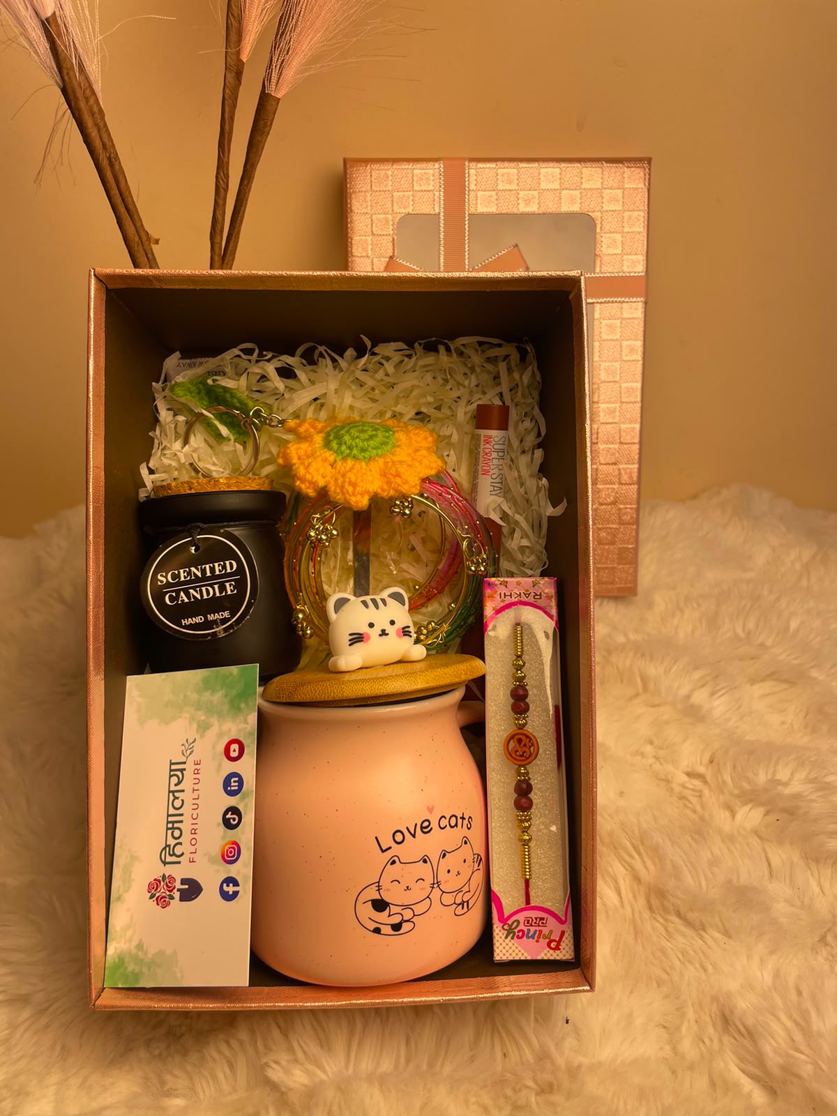 Product colours, designs, patterns, and packaging may vary slightly from the images shown due to availability and screen settings. The exact lipstick shade, mug design, keyring design, candle fragrance, and bangle pattern may vary.