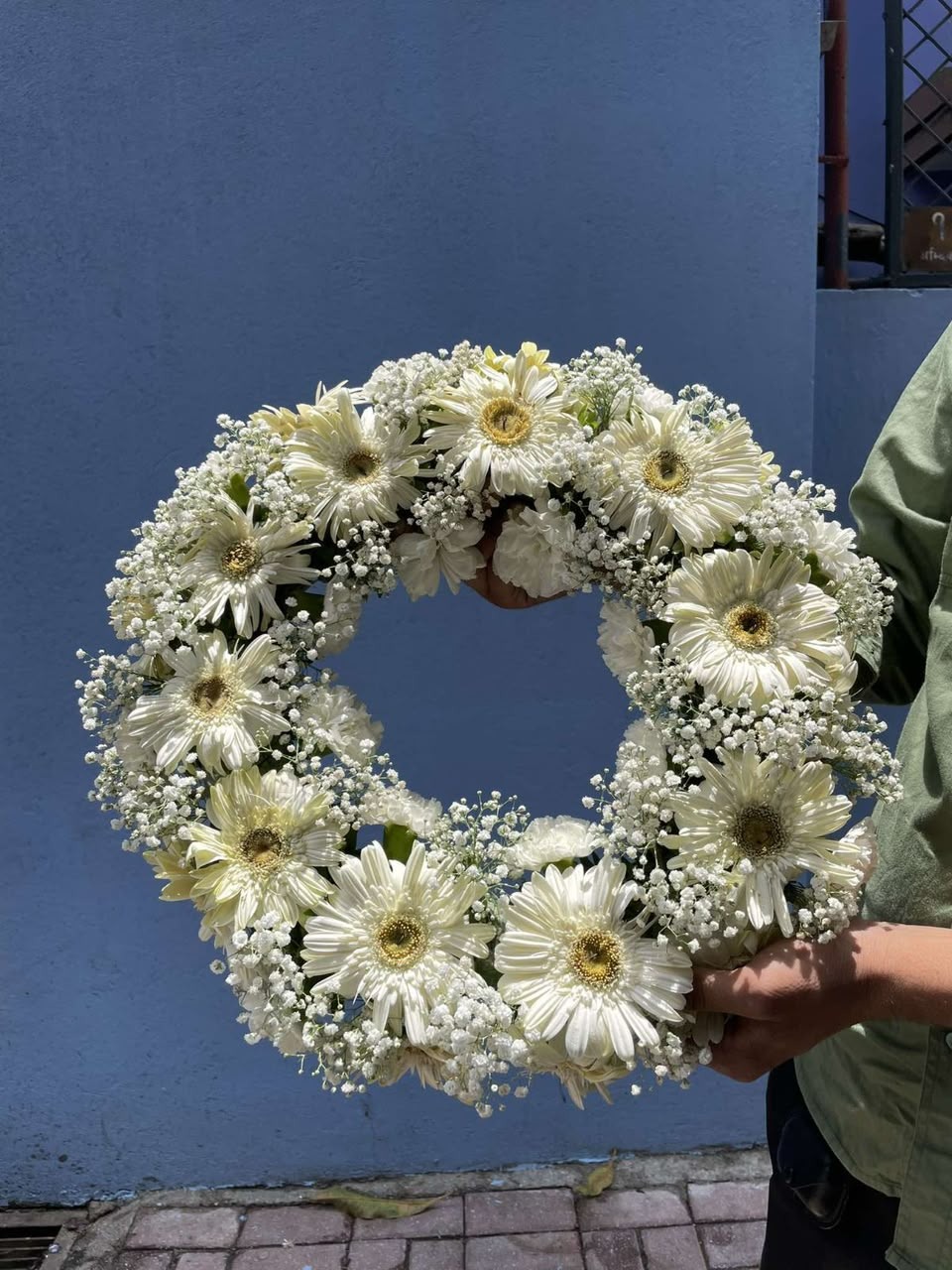 Flower varieties, sizes, quantities, and fullness may vary slightly depending on seasonal availability. Fresh flowers are naturally unique and may have minor variations in shape, size, and appearance. Gypsy flowers may be replaced with a similar white filler if unavailable, while maintaining the overall white theme and dignified appearance of the arrangement.